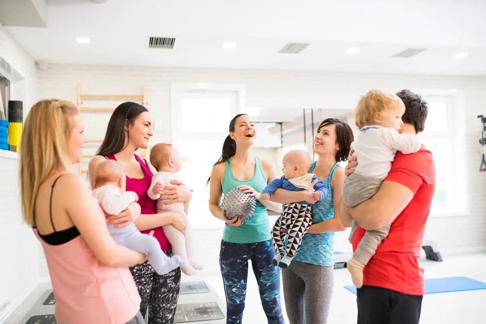 Bebekleriyle birlikte spor salonunda bir araya gelen ebeveynlerin sohbet edip sosyalleştiği anne grubu etkinliği.