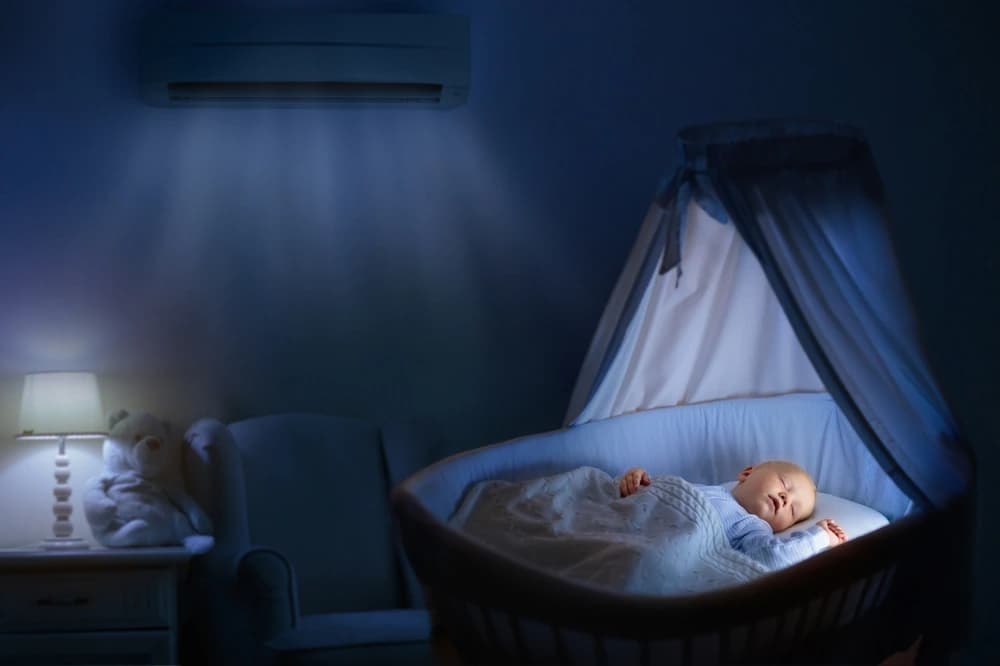 Klima çalışan loş bir odada, beşiğinde huzurla uyuyan bebek